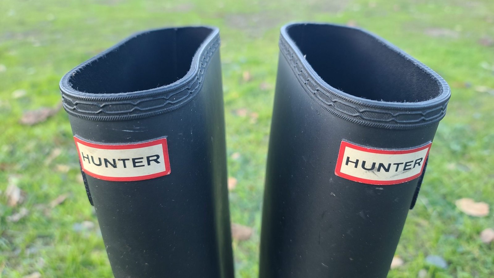 Before and after cleaning Hunter rain boots with bloom removal, micro fiber cloth, and rubber conditioner on wooden floor.