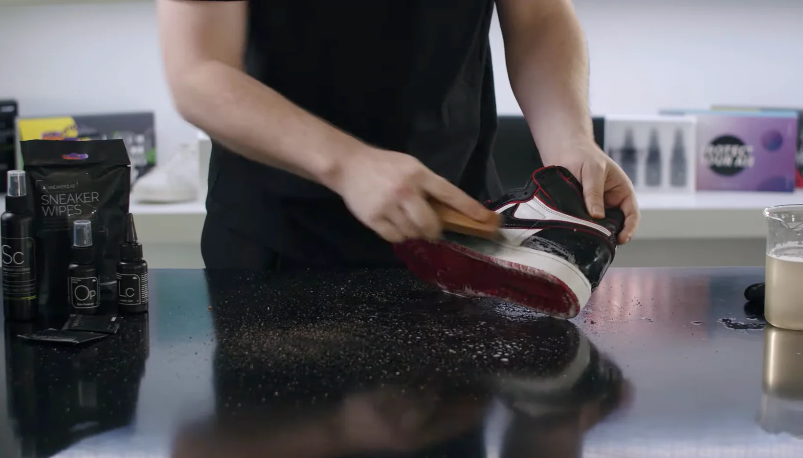 Step-by-step visual showing how to clean Jordans with brushes, suede eraser, and sneaker cleaner on a wooden workbench