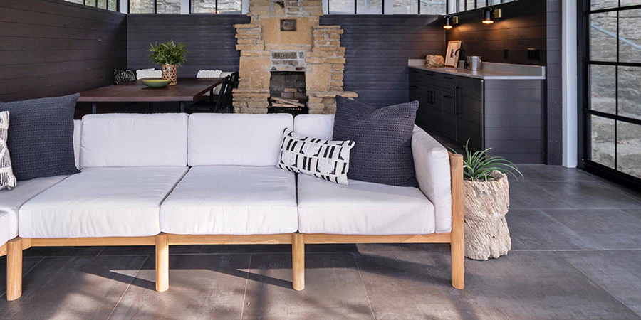 Step-by-step guide to cleaning Polywood outdoor cushions with soap, brush, and hose on a patio table showing wet, clean fabric.